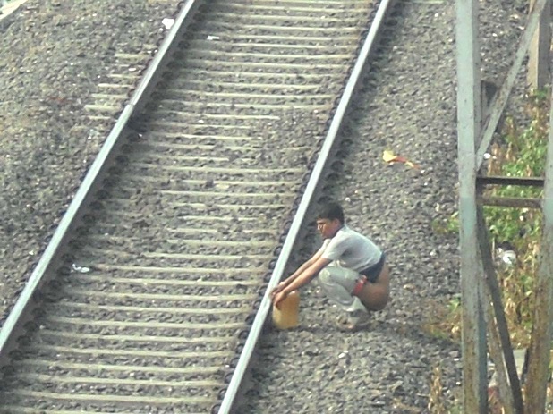 The picture above shows open defecation near railway track in India.